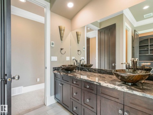 Dual vessel sinks with dark bronze fixtures, set on a dark granite countertop with white veining - 2807 Wheaton Drive, Edmonton, AB 