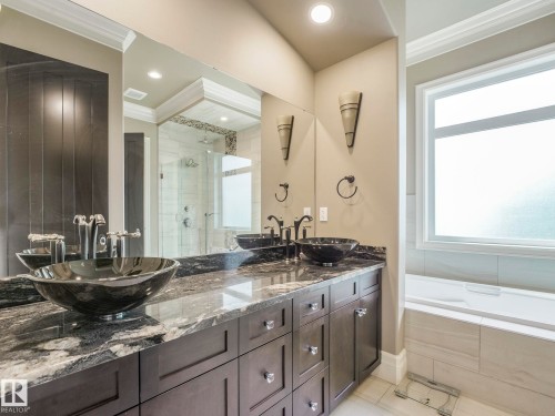 Dual vessel sinks with bronze fixtures set into a variegated stone countertop - 2807 Wheaton Drive, Edmonton, AB 
