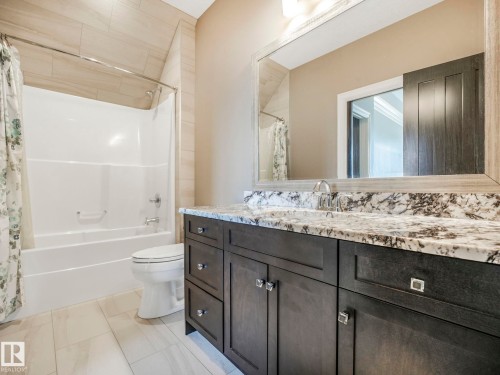 Bathroom featuring a single vanity with dark cabinetry and a light-toned countertop - 2807 Wheaton Drive, Edmonton, AB 