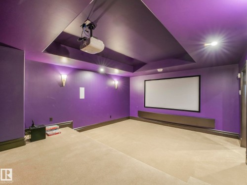 Dedicated media room featuring a ceiling-mounted projector, large projection screen, and integrated wall speakers - 2807 Wheaton Drive, Edmonton, AB 