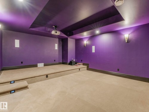 Dedicated media room featuring a raised platform, recessed ceiling with integrated lighting, wall-mounted sconces, and built-in speakers - 2807 Wheaton Drive, Edmonton, AB 