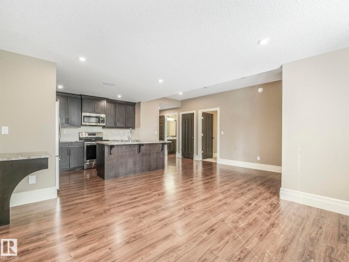 Spacious room featuring wood-finish flooring, recessed lighting, and crown molding - 2807 Wheaton Drive, Edmonton, AB 