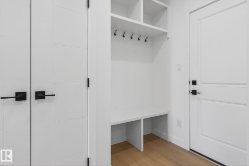 Built-in mudroom bench with cubby storage, integrated coat hooks, and upper shelving - 105 Wyatt Ridge, Fort Saskatchewan, AB 