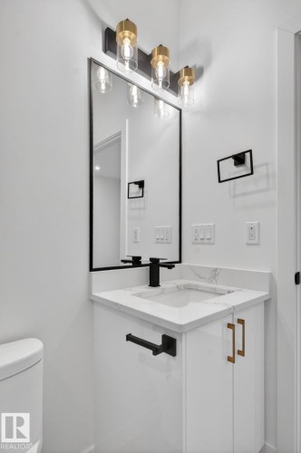 Bathroom vanity featuring a white quartz-finish countertop, integrated sink, and matte black faucet - 105 Wyatt Ridge, Fort Saskatchewan, AB 