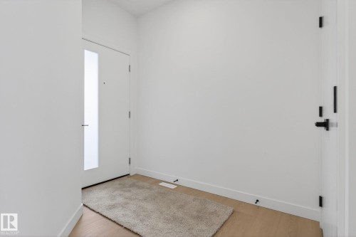 Entryway featuring a contemporary white door with a frosted glass insert and modern black hardware - 105 Wyatt Ridge, Fort Saskatchewan, AB 