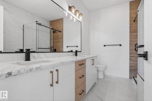Double vanity with integrated sinks, white cabinetry, and wood-finish drawer accents - 105 Wyatt Ridge, Fort Saskatchewan, AB 