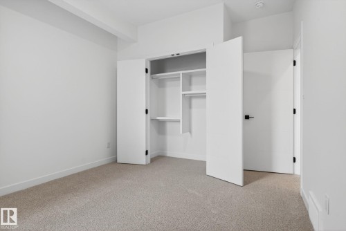 Bedroom featuring light-toned carpeting, crisp white walls, and a recessed ceiling light - 105 Wyatt Ridge, Fort Saskatchewan, AB 