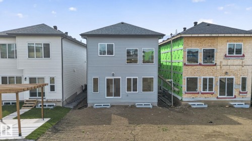 Gray vinyl-sided exterior featuring multiple windows and sliding glass doors - 105 Wyatt Ridge, Fort Saskatchewan, AB 
