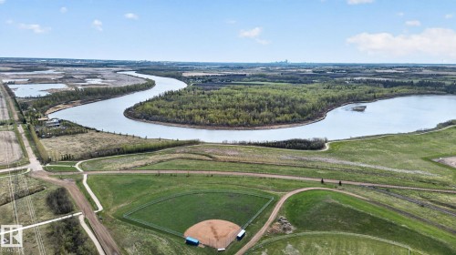 Expansive aerial landscape featuring a winding river, dense woodlands, and a clear blue sky - 105 Wyatt Ridge, Fort Saskatchewan, AB 