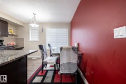 Kitchen and dining area featuring dark wood-finish cabinetry, a granite-style countertop, and wood-finish flooring - 