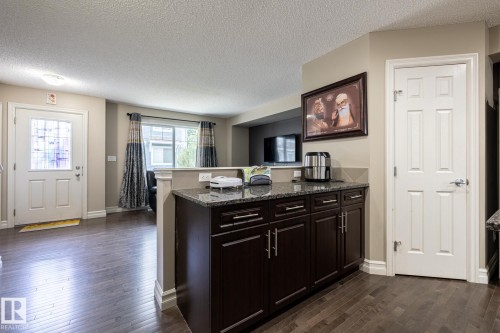 Dark wood-finish flooring throughout the main level - 59 655 Tamarack Road, Edmonton, AB 