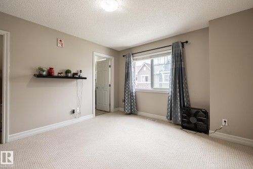 Bright room featuring light beige wall paint, white trim, and light-colored carpeting - 59 655 Tamarack Road, Edmonton, AB 