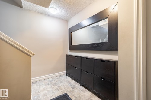 Tiled flooring in a neutral palette, complemented by a white baseboard - 59 655 Tamarack Road, Edmonton, AB 