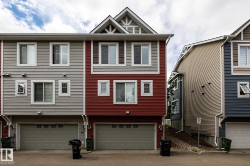 Red-sided townhome featuring a two-story elevation with a prominent front-facing gable - 59 655 Tamarack Road, Edmonton, AB 