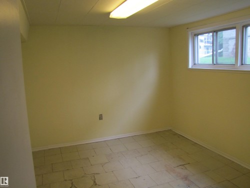 Room with light yellow painted walls, white trim, and a drop ceiling - 8122 83 Avenue, Edmonton, AB 