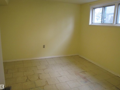 Room with light yellow painted walls, white trim, and a window featuring a white frame - 8122 83 Avenue, Edmonton, AB 