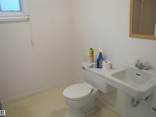 White toilet and wall-mounted sink with a chrome faucet - 8122 83 Avenue, Edmonton, AB 