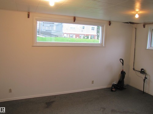 Finished room featuring two windows, recessed lighting, and carpeted flooring - 8122 83 Avenue, Edmonton, AB 