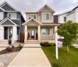 Two-story residence featuring a covered front porch, light-colored siding, and a gabled roofline - 5281 Edgemont Boulevard, Edmonton, AB 