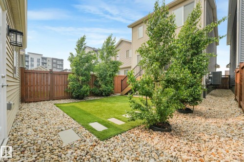 Private backyard featuring a central lawn area, surrounded by decorative river rock landscaping - 5281 Edgemont Boulevard Nw, Edmonton, AB - Outdoor