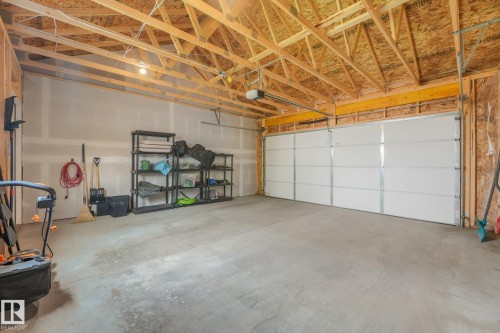 Spacious garage featuring a concrete floor and exposed wood framing - 5281 Edgemont Boulevard Nw, Edmonton, AB - Indoor Photo Showing Garage