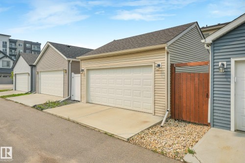 Detached garage with horizontal siding, a paneled garage door, and a shingle roof - 5281 Edgemont Boulevard Nw, Edmonton, AB - Outdoor