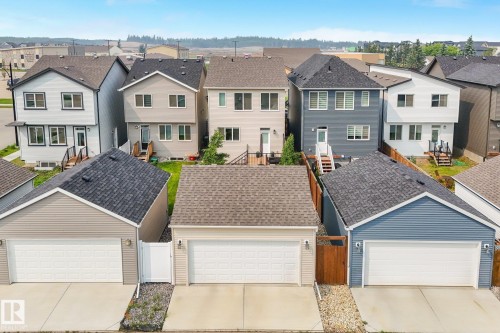 Rear-facing garages with concrete driveways and architectural shingle roofs - 5281 Edgemont Boulevard Nw, Edmonton, AB - Outdoor With Facade