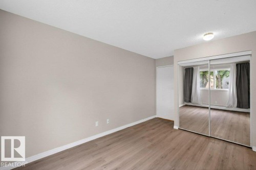 Room with wood-finish flooring, neutral wall paint, and white baseboards - 103 10620 104 Street Nw, Edmonton, AB 