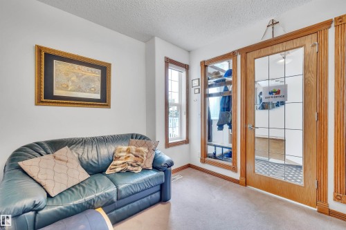 Entry area featuring a glass-paneled interior door with a wood frame, complementing window trim, and carpeted flooring - 16512 87 Street, Edmonton, AB 