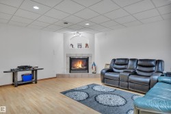 Corner fireplace with a tile surround and hearth, featuring an arched niche with recessed lighting - 