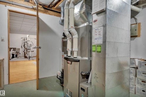 Utility room featuring a furnace with visible ductwork and piping - 16512 87 Street, Edmonton, AB 