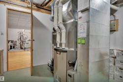 Utility room featuring a furnace with visible ductwork and piping - 