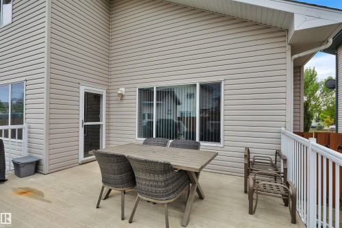 Expansive outdoor deck featuring light-colored siding, a white railing, and multiple windows - 16512 87 Street, Edmonton, AB 
