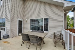 Expansive outdoor deck featuring light-colored siding, a white railing, and multiple windows - 