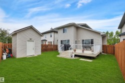 Expansive backyard, a large elevated deck with white railings, and a detached storage shed *Lawn has been Virtually enhanced* - 
