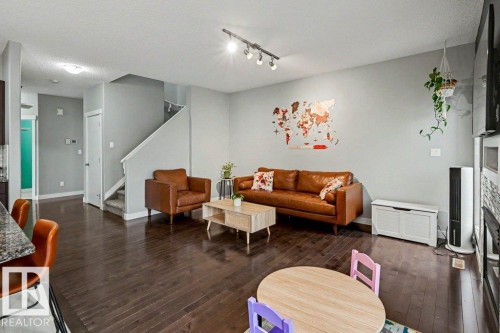 Spacious room featuring dark wood-finish flooring, light gray wall paint, and recessed lighting - 13004 164 Avenue, Edmonton, AB 