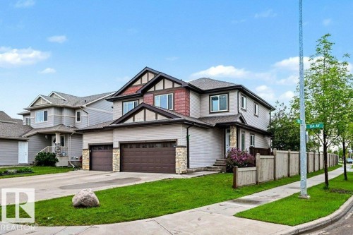 Two-story residence featuring a two-car attached garage, stone accents on the facade, and a prominent front entrance - 13004 164 Avenue, Edmonton, AB 