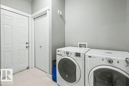 Laundry area featuring light gray walls, white baseboards, and light-toned tile flooring - 13004 164 Avenue, Edmonton, AB 