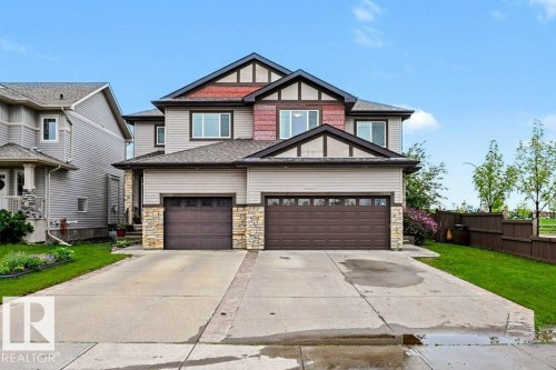Two-story residence featuring a dual garage, stone accents, horizontal siding, and prominent gables - 13004 164 Avenue, Edmonton, AB 