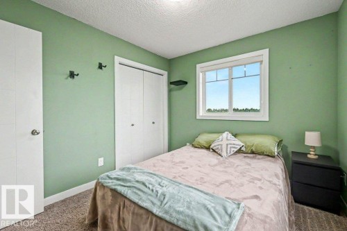 Bedroom featuring green walls, a white-framed window, and textured carpeting - 13004 164 Avenue, Edmonton, AB 