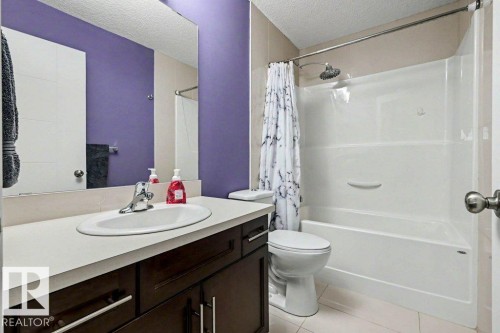 Full bathroom featuring a single vanity with dark wood-finish cabinetry, a white countertop, and an integrated sink - 13004 164 Avenue, Edmonton, AB 