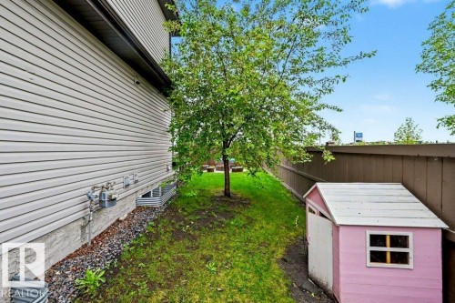 Side yard featuring a mature tree, privacy fencing, and a compact storage shed - 13004 164 Avenue, Edmonton, AB 