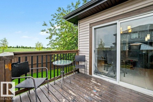 Exterior deck with wood decking and railing overlooking a green expanse - 13004 164 Avenue, Edmonton, AB 