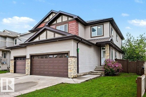 Multi-level exterior featuring light-colored siding, dark trim, and decorative stone accents - 13004 164 Avenue, Edmonton, AB 
