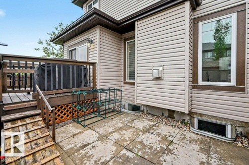 Exterior patio with flagstone paving and a raised wooden deck with railings - 13004 164 Avenue, Edmonton, AB 