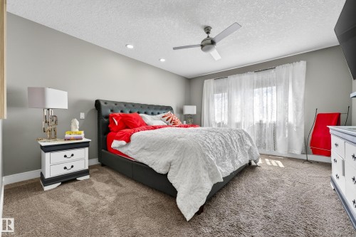 Carpeted room featuring a ceiling fan, recessed lighting, and a large window with sheer white curtains - 311 Genesis Vi, Stony Plain, AB 