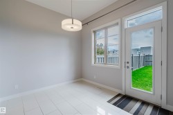 Contemporary interior space featuring light gray walls, large format tile flooring, and a modern drum pendant light fixture - 