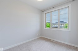 Carpeted room with light gray walls, a large multi-pane window, and white trim - 