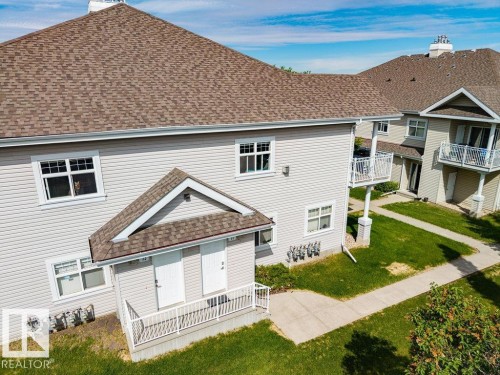 Multi-unit building exterior featuring light-colored horizontal siding and brown shingle roofing - 71 3040 Spence Wynd, Edmonton, AB 