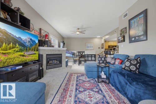 Living area featuring a gas fireplace with a tiled surround and mantel - 71 3040 Spence Wynd, Edmonton, AB 